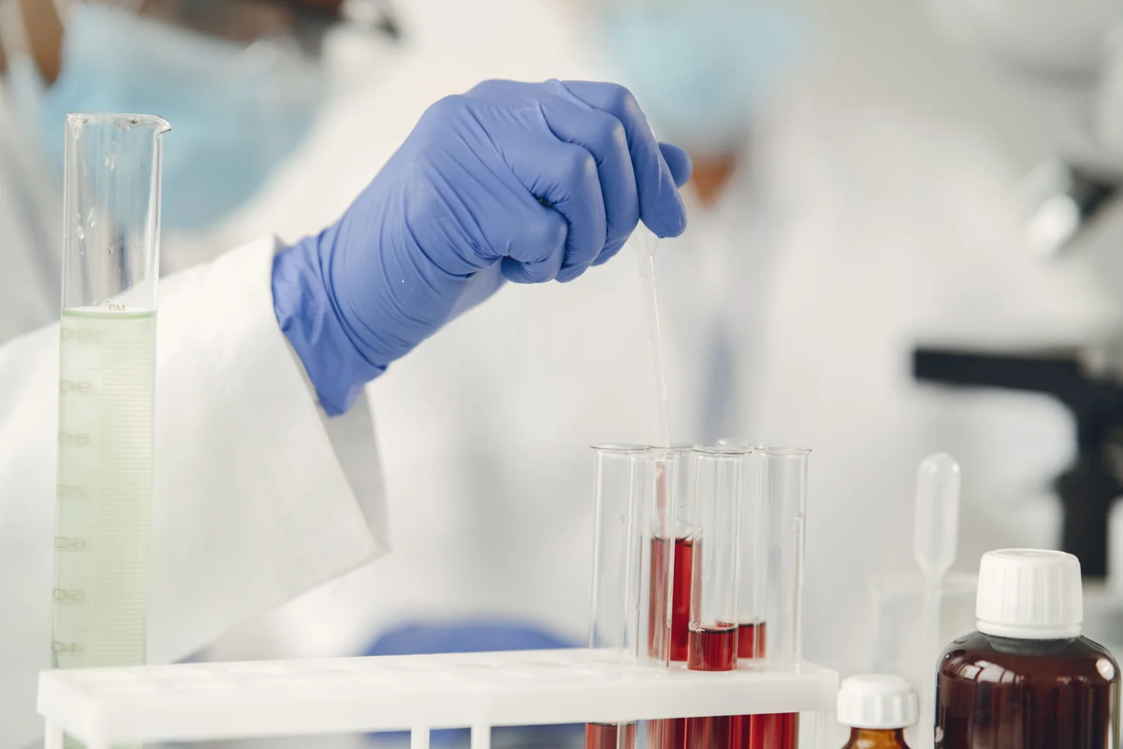 Lab technician working with test tubes and a pipette