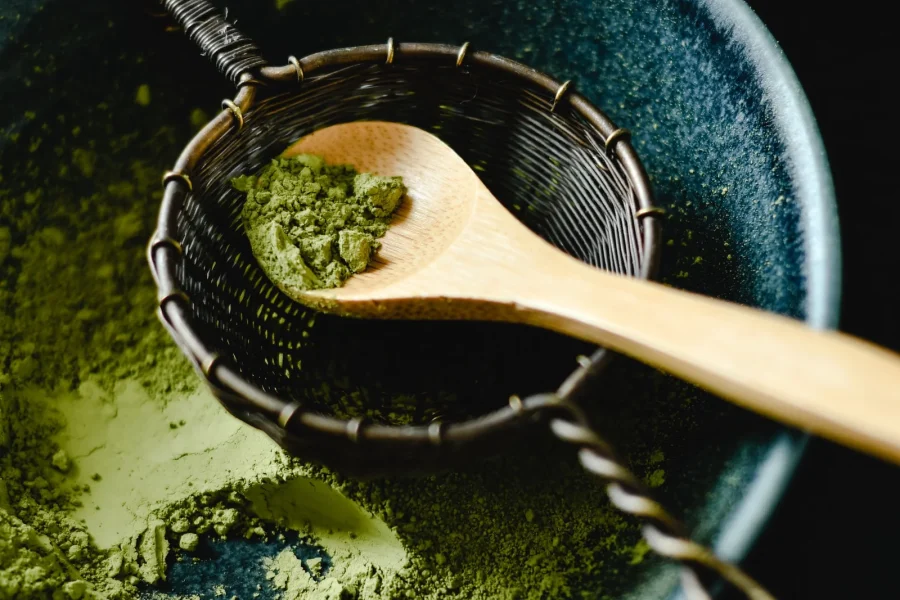 Wooden spoon and sieve with fine green powder